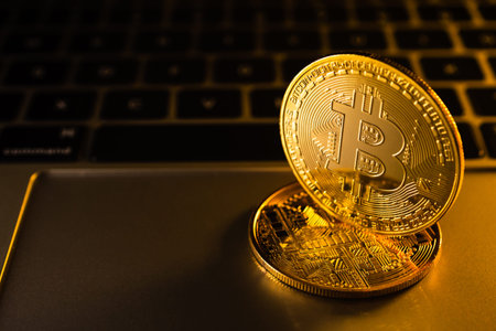Golden coins with bitcoin symbol on computer.