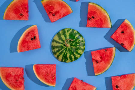 Top view of fresh ripe watermelon slices on blue background.の写真素材