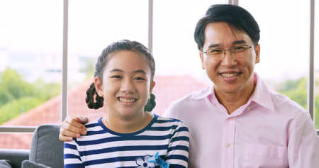 Portrait of Happy family with father and daughter smiling and looking at camera.の写真素材