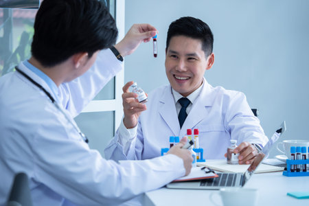 Scientist discussing with colleague about covid 19 vaccine in meeting room at hospital
