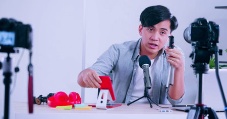 Young Asia man selling digital gadgets on social media by streaming live from his home.