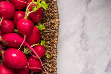 Top view of red ripe radishes in a basket with grunge backgroundの写真素材