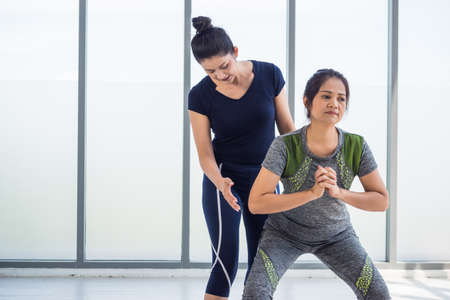 Two asian women doing yoga together at a gym.の写真素材