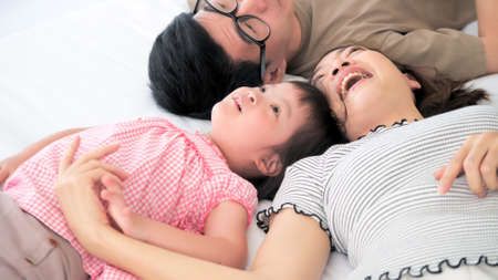 Happy family with mother, father and disabled daughter spending time together at homeの写真素材