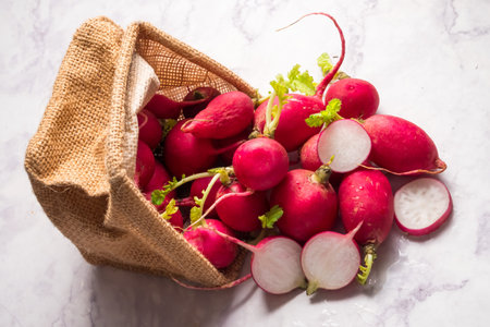 Sliced red ripe radishes in a basket with grunge background