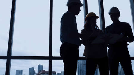 Team of young Asian architects discussing on construction site.の写真素材