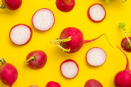 Red ripe sliced radish on yellow backgroundの写真素材