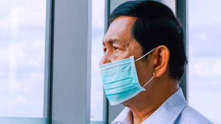 Senior man wearing protective face masks during quarantine at home.の写真素材