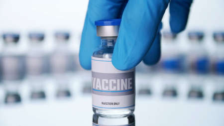 Close up, Scientist is holding a glass vial for vaccine in laboratory.の写真素材