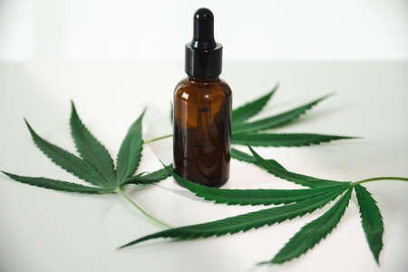 Cannabis oil in the dropper bottle with green leaves. Alternative medicine concept.の写真素材