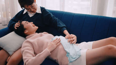 Pregnant Asian lesbian woman and her partner are happy to spend time together at home.の写真素材