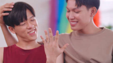 Happy gay Asian couple showing off their wedding ring.の写真素材