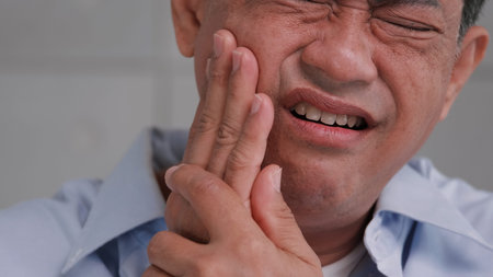Asian senior man suffering from toothache.