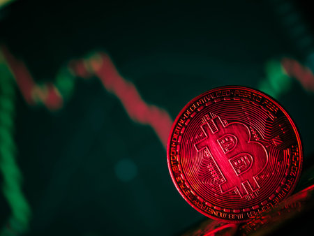Coins with bitcoin symbol on red light and crypto stocks chart background. Concept of a...