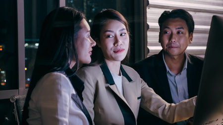 Businesswoman explaining work project to colleague and rushing to work together until late at night.