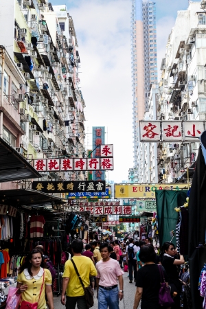 Busy shoppers stroll along Sham Shui Po street market where vendors line the street selling diverse products ranging from clothing, toys and sportswear to souvenirs and foods of all kinds  のeditorial素材