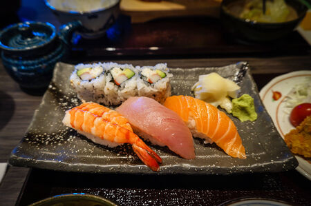 Plate of nigiri sushi featuring Ebi (shrimp), Maguro (tuna) and Sake (Salmon) in a Japanese dining setting.の写真素材