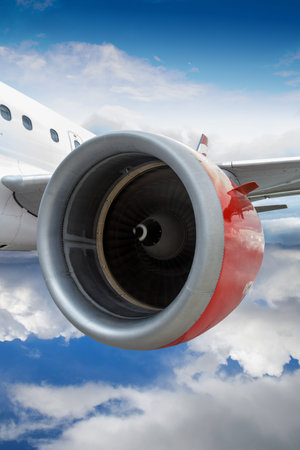 Commercial airplane with red engine in flight through clouds. Realistic engine spinning motion on...