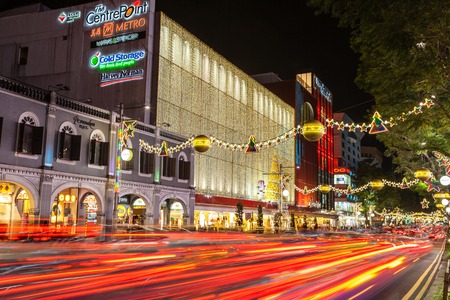 Night view of famous festive Orchard Road in Singapore. Colorful street decorations and motion blur on streaking traffic tail lights during Christmas season.のeditorial素材