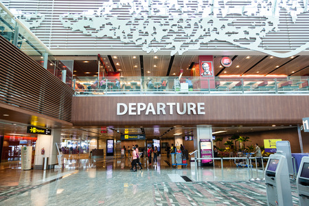 Travelers walk about Singapore Changi Airport's departure hall. With three passenger terminals it is one of the largest transportation hubs in Asia with a total annual handling capacity of 66 million passengers.のeditorial素材