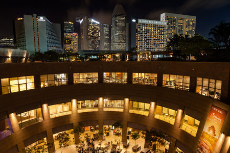 The Esplanade theater at night with Singapore's skyline in the background. The iconic building on Marina Bay contains a concert hall a public library and a shopping mall.のeditorial素材