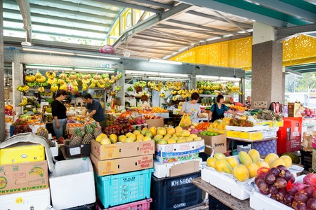Local residents shopping for fruits and vegetables at a local wet market in Singapore. For residents, a wet market is the place to buy groceries and the freshest produce.のeditorial素材