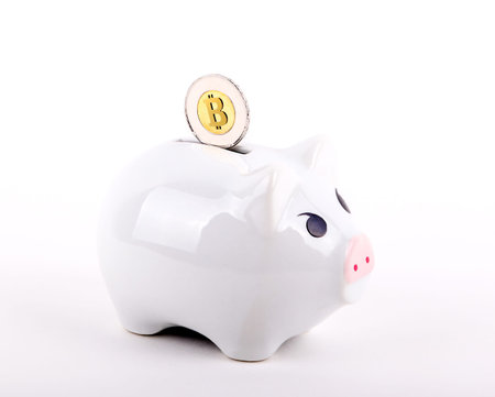 A conceptual image of Bitcoin, a popular virtual currency, deposited into a piggy bank. Isolated on...
