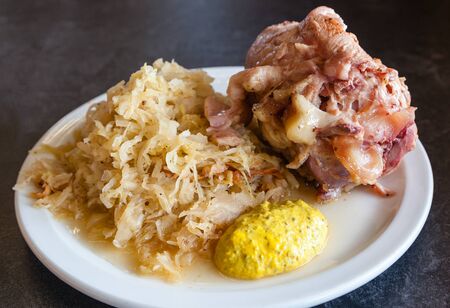 Traditional German ham hock or pork knuckle served with sauerkraut.の写真素材
