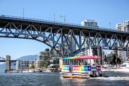 Vancouver, Canada - July 26, 2010: An Aquabus ferry approaches Granville Island Bridge on False Creek in downtown Vancouver. The popular water taxi service around Granville Island and False Creek destinations.のeditorial素材