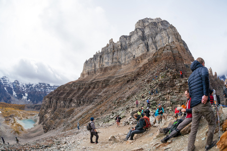 Lake Louise, Canada - September 17, 2016: Hikers rest atop Sentinel Pass in the Larch Valley near Lake Louise in Banff National Park, Alberta, with Pinnacle Mountain and Valley of Ten Peaks in the background.のeditorial素材