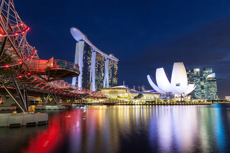 SINGAPORE- September 6, 2017: The brightly lit Helix Bridge leads to the Marina Bay Sands hotel with the iconic ArtScience Museum in the background.のeditorial素材