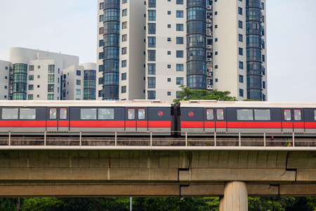 SINGAPORE - SEPTEMBER 11, 2017: Singapore's Mass Rapid Transit (SMRT) subway train travels on elevated rails through a public housing estate. The SMRT is the second-oldest metro system in Southeast Asia, after Manila Light Rail Transit System.のeditorial素材