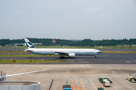 TOKYO, JAPAN - JUNE 15, 2015: A Cathay Pacific Airways plane on the runway of Tokyo Narita Airport. Hong Kong's flagship airline, it made the world's first non-stop transpolar flight flying over the North Pole in July 1998.のeditorial素材