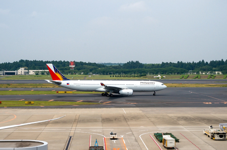 TOKYO, JAPAN - JUNE 15, 2015: A Philippine Airlines plane on the runway of Tokyo Narita Airport. Founded in 1941, it is the first and oldest commercial airline in Asia operating under its original name.のeditorial素材