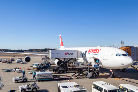 TOKYO, JAPAN - DEC. 5, 2014: A Swiss International Air Lines plane being serviced on the tarmac of Tokyo Narita Airport. The airline was formed after the 2001 bankruptcy of Swissair, Switzerland's former flag carrier.のeditorial素材