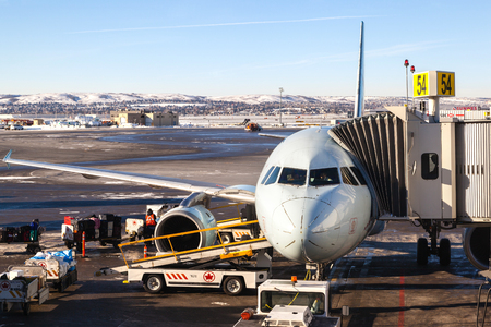 CALGARY, CANADA - DEC. 4, 2014: Ground crew loads baggage and pilots prepare an Air Canada plane for takeoff on the tarmac of Calgary International Airport.のeditorial素材