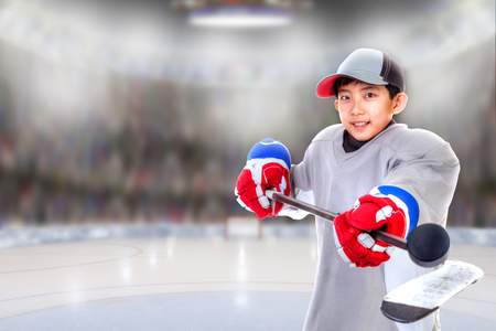 Junior hockey player posing on ice in sports arena. Shallow depth of field on background and copy space.の写真素材