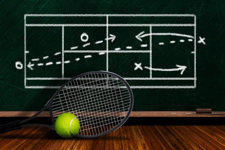 Tennis racket and ball on table with background players' doubles strategy on chalkboard and copy space.の写真素材