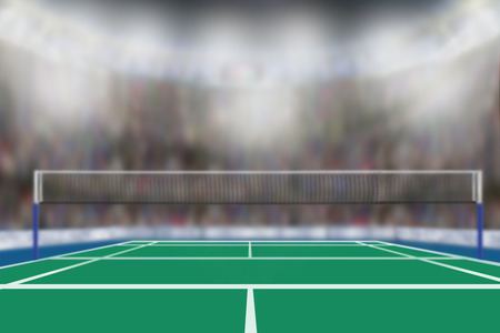 Low angle view of badminton arena with sports fans in the stands and copy space. Focus on foreground with deliberate shallow depth of field on background.