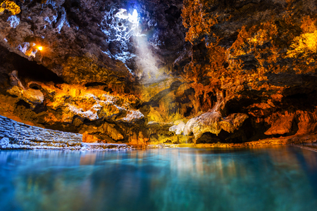 Beam of light shines through an opening in the underground cave onto the thermal hotspring waters at Cave and Basin National Historic Site, the birthplace of Canada's national parks in Banff. In 1883, three railway workers stumbled on the Cave, an event that gave rise to Canada's first national park.の写真素材