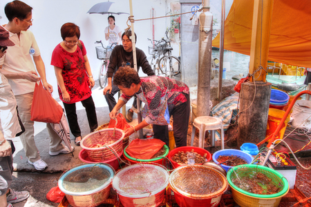 HONG KONG - APR 10, 2011: A street vendor in Tai O selling live seafood harvested from this seaside fishing village on Lantau Island in Hong Kong.のeditorial素材