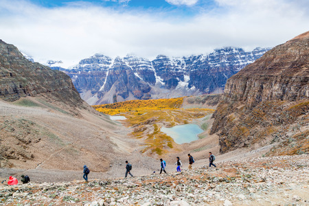 LAKE LOUISE, CANADA - SEPT 17, 2016: Hikers traverse the rocky trail at Sentinel Pass in the Larch Valley near Lake Louise in Banff National Park, Alberta, with snow-capped Valley of Ten Peaks in the background and Larch trees around Minnestimma Lakes in のeditorial素材