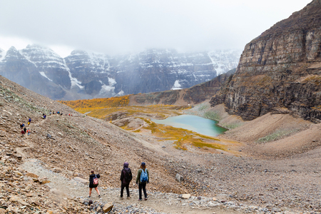 LAKE LOUISE, CANADA - SEPT 17, 2016: Hikers traverse the rocky trail at Sentinel Pass in the Larch Valley near Lake Louise in Banff National Park, Alberta, with snow-capped Valley of Ten Peaks in the background and Minnestimma Lakes in the valley.のeditorial素材