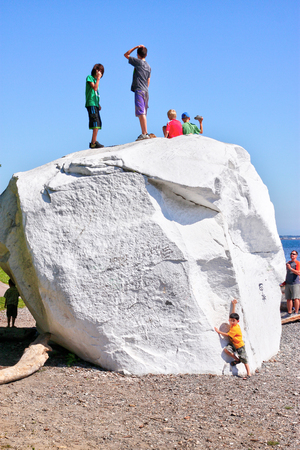 WHITE ROCK, CANADA - JULY 23, 2010: Kids climbing on top of the famous boulder at the coastal city of White Rock, British Columbia, near Vancouver. The area is popular for its 2.5 km long beach promenade and this large white rock that weighs 486 tons. Theのeditorial素材