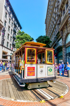 SAN FRANCISCO - APR 2, 2018: A worker rotates a cable car at the Powell and Market street turntable to pick up a crowd of passengers. A San Francisco historic icon, it's the world's last manually operated cable car system.のeditorial素材