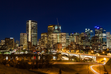 Calgary downtown skyline at sunset blue hour showing Centre Street Bridge across the Bow River and surrounding skyscrapers of the financial business district and Chinatown.のeditorial素材