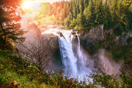 Morning sun peeks through the trees at Snoqualmie Falls in Washington State near Seattle. The waterfall is sacred to the Snoqualmie native indians who have lived for centuries in the Snoqualmie Valley. It is listed on the National Register of Historic Places.の写真素材