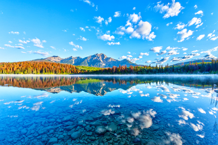 Sunrise over Patricia Lake in Jasper National Park with Pyramid Mountain in the background and misty fog on the water's surface. Calm waters create serene reflections.の写真素材