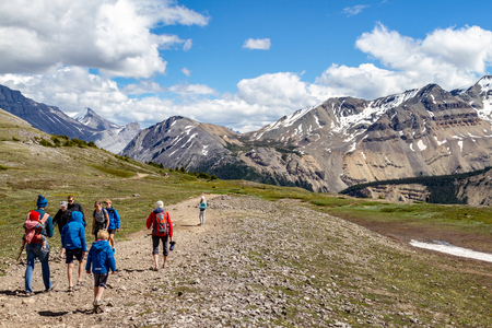 JASPER, CANADA - JUL 8, 2018: Hikers at the crest of Parker Ridge on the Icefields Parkway in Jasper National Park with the Canadian Rockies in the background.のeditorial素材