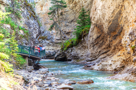 BANFF, CANADA - JUL 30, 2018: Visitors sightseeing at Johnston Canyon of Banff National Park, a popular hiking trail through the walkway on the limestone canyon walls.のeditorial素材